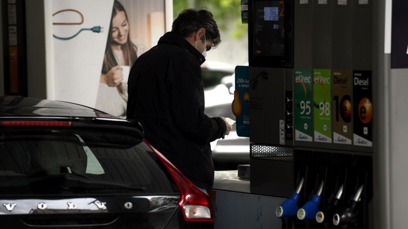 Un hombre echa gasolina a su coche en una gasolinera.