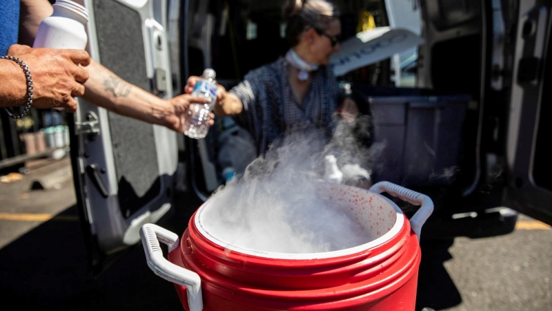 La gente usa hielo seco para enfriar agua y Gatorade debido a la escasez de hielo durante una ola de calor sin precedentes en Portland, Oregon.