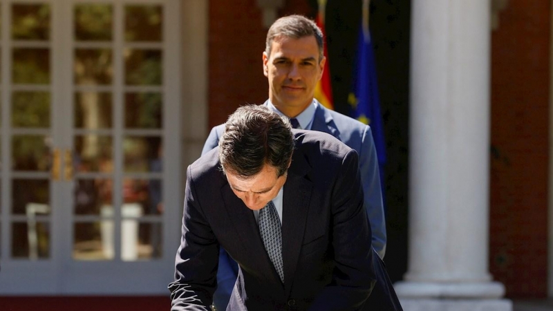 El presidente del Gobierno, Pedro Sánchez (detrás) y el presidente de la CEOE, Antonio Garamendi, durante la firma del acuerdo para la reforma de las pensiones este jueves en el palacio de la Moncloa en Madrid.
