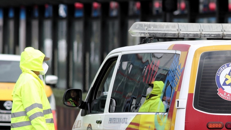 Una trabajadora habla con el conductor de una ambulancia del SAMUR