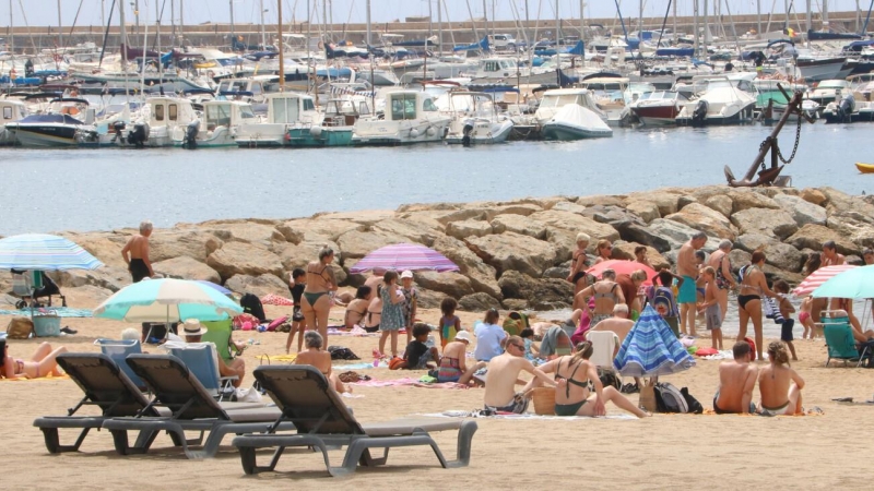Diverses persones a la platja de Sant Feliu de Guíxols. Imatge publicada el 7 de juliol del 2021