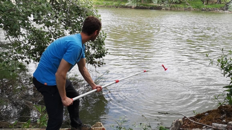 Un voluntario recoge muestras de agua del río Torío a su paso por León, cerca de un vertedero ilegal.