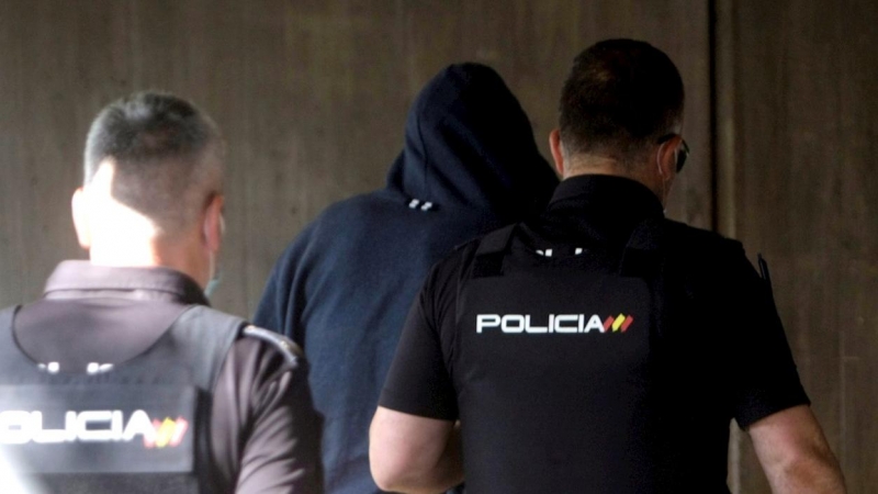 Agentes de la Policía Nacional conducen a uno de los cuatro detenidos por el homicidio de Samuel este viernes al interior de los juzgados de la Coruña.