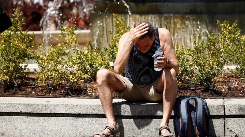 Un hombre se echa agua por la cara durante la ola de calor en Madrid.