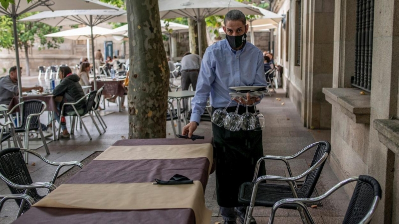 Un camarero recoge una mesa en la terraza de su restaurante, en Ourense.