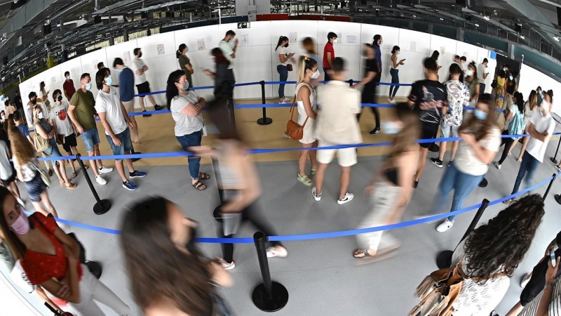 Cientos de personas, entre los que se encuentran los jóvenes mayores de 16 años, hacen cola en el hospital Enfermera Isabel Zendal de Madrid, para ser vacunados frente al coronavirus, el pasado martes 13 de julio.