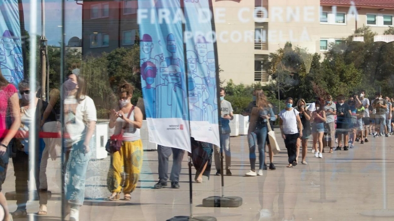Una cola de personas esperan para entrar al centro de vacunación masiva, instalado en la Fira de Cornellà (Barcelona)