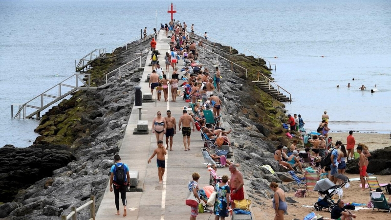 Varias personas disfrutan este sábado en la playa de Candas.