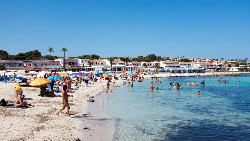 Decenas de personas disfrutan del sol en la playa de Punta Prima (Menorca).