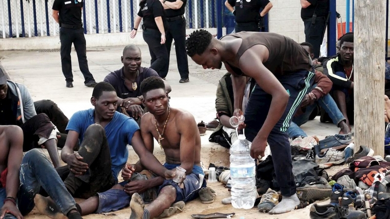 Migrantes en MelillaUn grupo de inmigrantes subsaharianos aguardan tras conseguir saltar la valla fronteriza de Melilla este jueves.