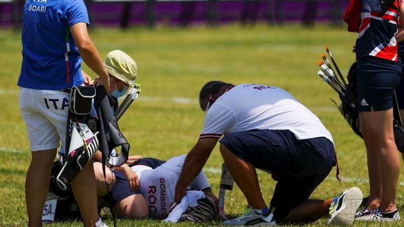 22/07/2021.- Svetlana Gomboeva (abajo) del equipo del Comité Olímpico Ruso (ROC) recibe atención al desmayarse por un golpe de calor hoy, durante la ronda de individual femenina de Tiro con arco por los Juegos Olímpicos 2020, en el campo de Yumenoshima en