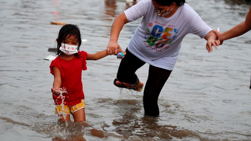 Una niña juega con el agua en Filipinas.