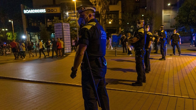 Agentes de la Guardia Urbana forman una línea tras desalojar la playa de la Barceloneta el 16 de julio de 2021.