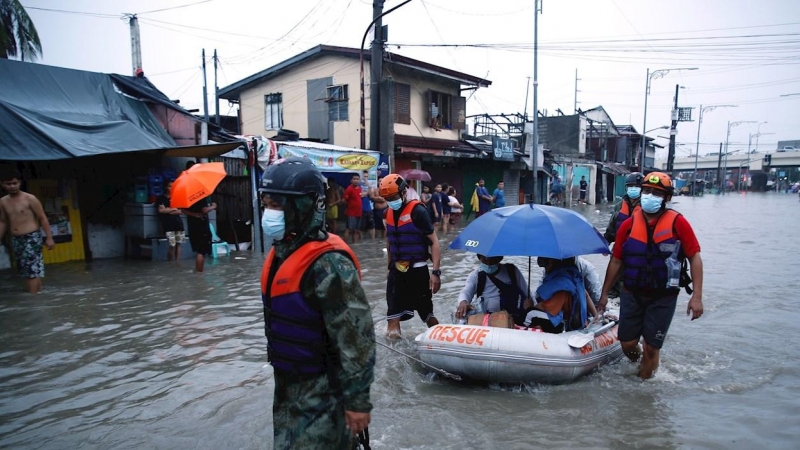 Los equipos de rescate ayudan a un grupo de personas a ponerse a salvo de las inundaciones.