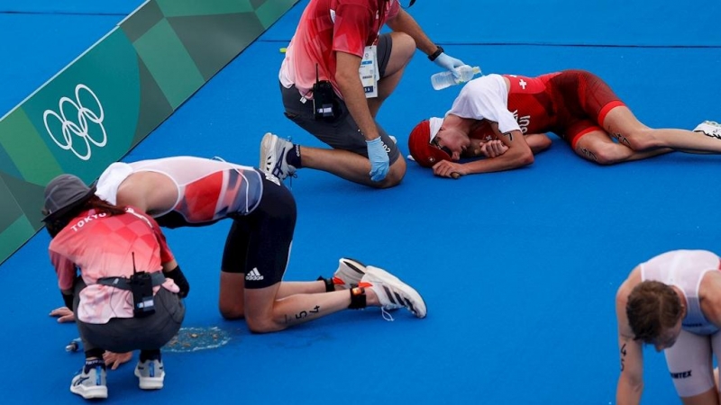 26/07/2021.- Jonathan Brownlee (i) de Gran Bretaña, Max Studer (c) de Suiza y Casper Stornes de Noruega descansan en el suelo tras cruzar la meta del triatlón masculino durante los Juegos Olímpicos 2020, este lunes en el parque marino de Odaiba en Tokio (