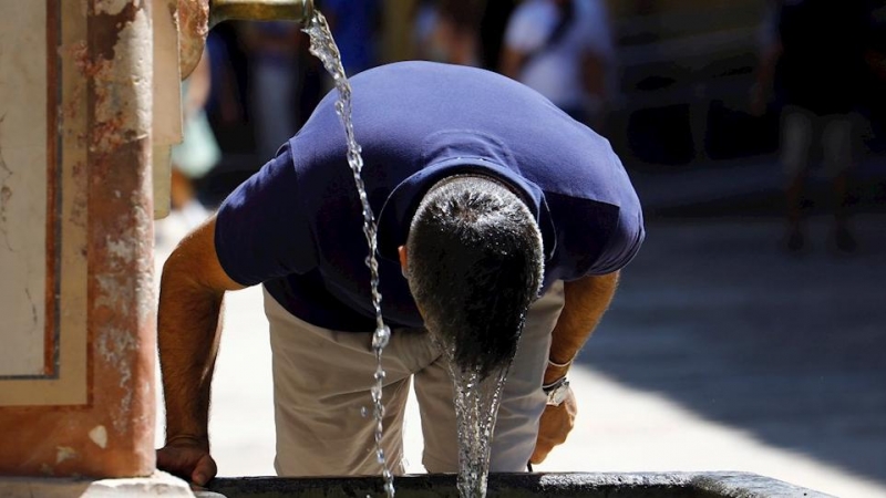 Un visitante se refresca en una fuente del Patio de los Naranjos de la Mezquita Catedral de Córdoba este sábado, en una jornada de intenso calor en la ciudad andaluza.