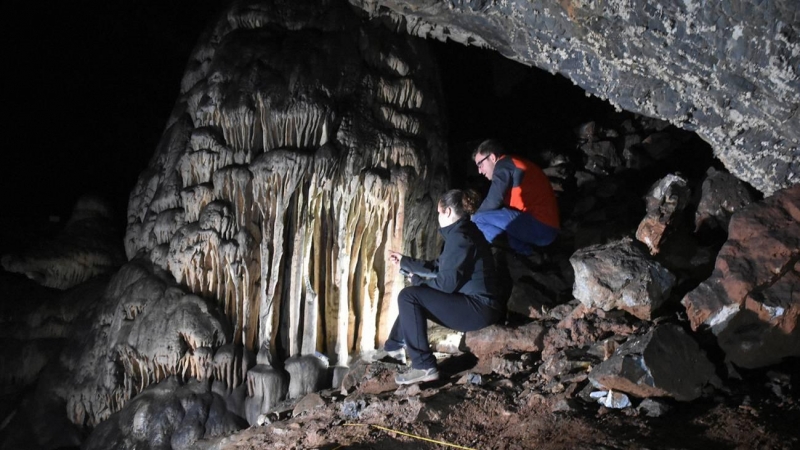Investigadores mirando hacia las estalagmitas del interior de la cueva de Ardales.