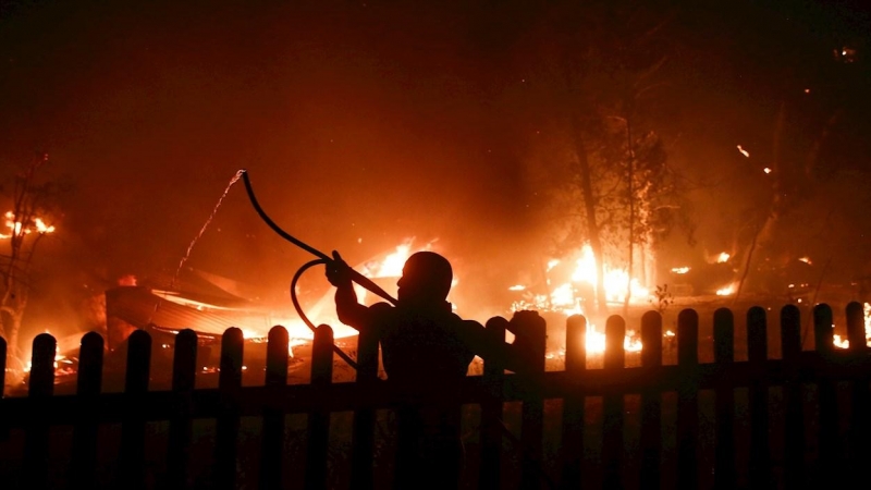 Un ciudadano intenta extinguir el fuego en Varybobi, Atenas.