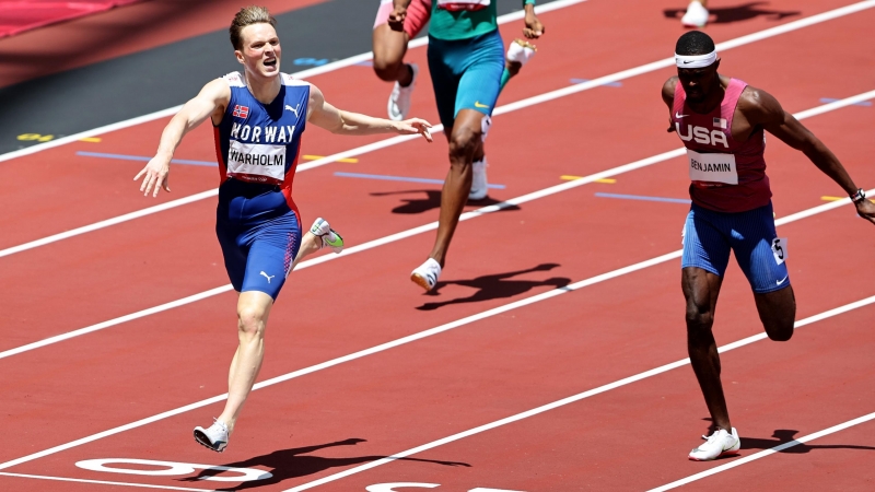 El noruego Karsten Warholm cruza la línea de meta y celebra el oro por delante del estadounidense Rai Benjamin.