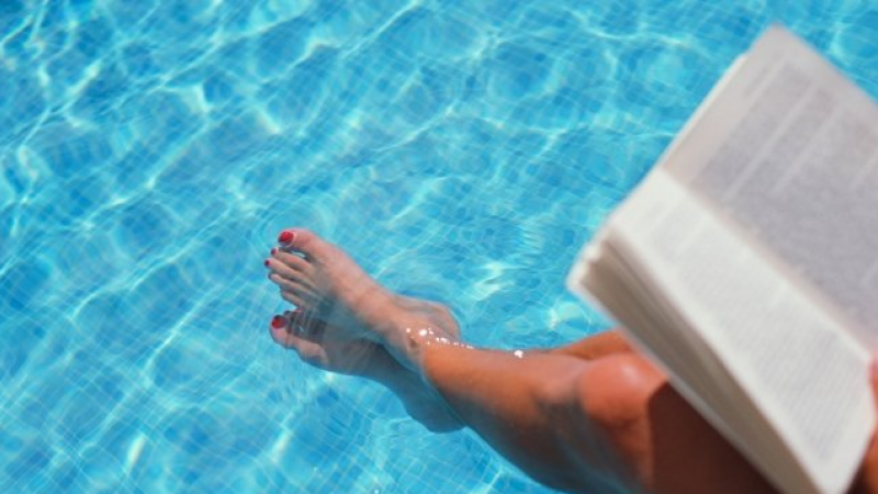Imatge d'una banyista llegint un llibre a la piscina.