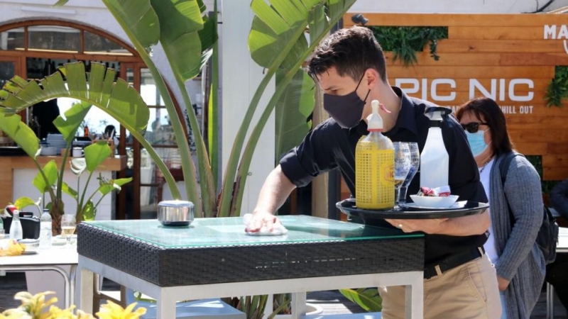 Un camarero de un restaurante de Sitges limpiando la mesa entre servicios de aperitivo