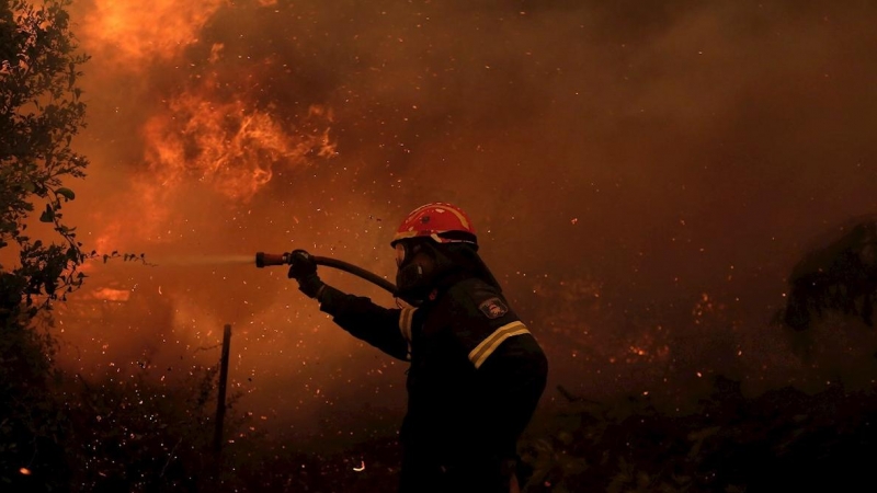 El bombero Nektarios Iakovakis lucha contra las llamas durante un incendio forestal en la aldea de Pefki en Evia, Grecia.