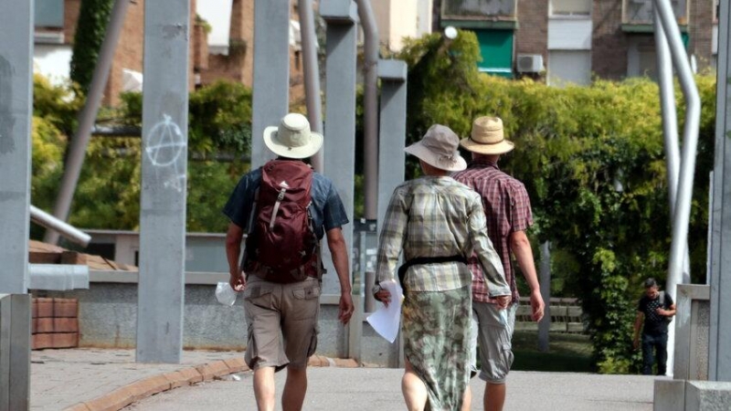 Tres turistes amb el cap cobert amb barrets per la calor, a Lleida.