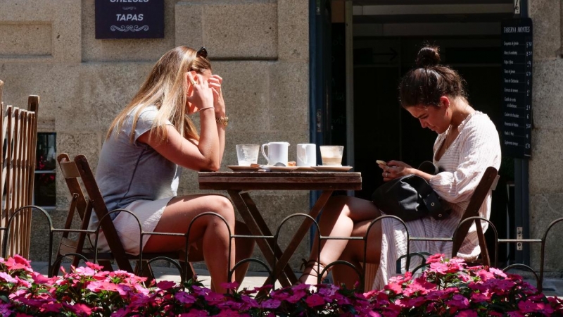Dos mujeres en la terraza de un restaurante de la Rua da Raiña, el día en que el TSXG declara nula la petición de certificado Covid para entrar en hostelería, a 12 de agosto de 2021, en Santiago de Compostela, A Coruña, Galicia