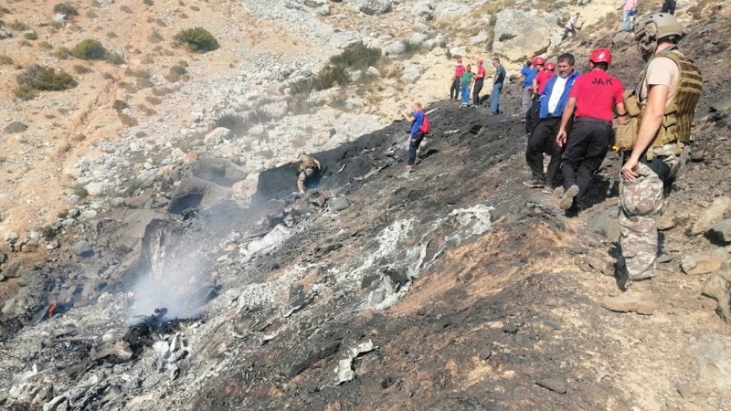 Miembros de los equipos de búsqueda y rescate inspeccionan el avión anfibio ruso Be-200 estrellado.