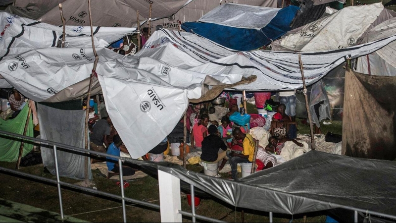 Las personas que perdieron sus hogares en el terremoto del pasado fin de semana en Haití se sientan bajo láminas de plástico en un campamento improvisado durante el paso de la tormenta tropical Grace. REUTERS / Ralph Tedy Erol