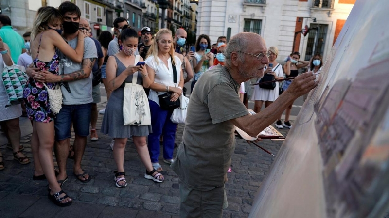 Varias personas observan trabajar al pintor  Antonio Lopez en la céntrica Puerta del Sol de  Madrid. REUTERS/Juan Medina