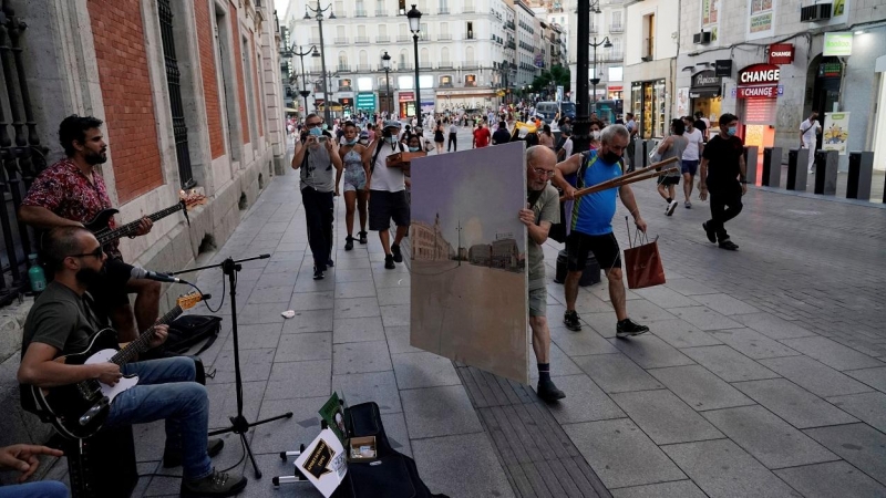 El pintor Antonio López lleva el lienzo en el que está pintando la Puerta del Sol de Madrid después de una jornada de trabajo en la misma plaza. REUTERS / Juan Medina