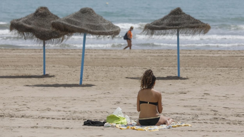 Una mujer toma el sol en una playa de Valencia.