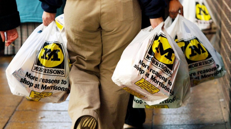 Un hombre va con sus compras en el supermercado Morrison en Bradford, Inglaterra.