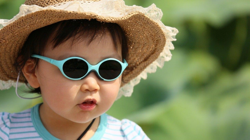 Niño con gafas de sol y sombrero.