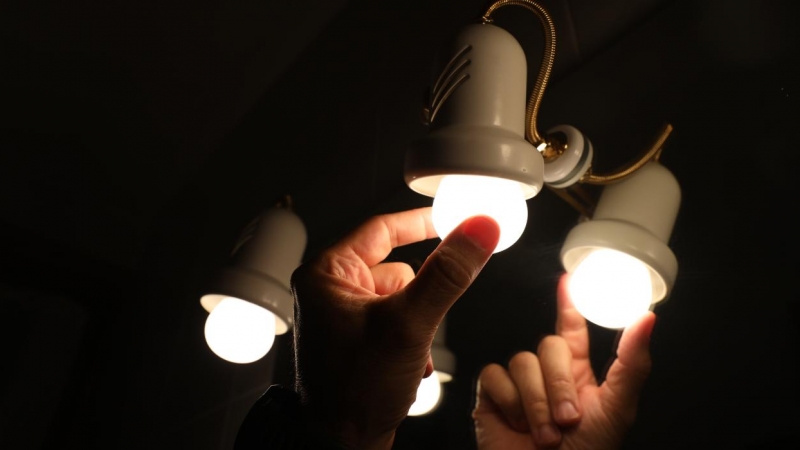 Una persona cambia la bombilla de una lámpara, el día en que el precio de la luz bate un récord histórico alcanzando los 124,45 euros por megavatio hora, a 30 de agosto de 2021, en Madrid, (España).