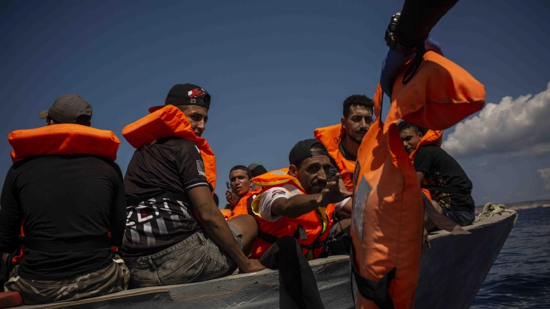 Un grupo de migrantes tunecinos reciben chalecos salvavidas de los socorristas de Open Arms a cuatro millas al sur de Lampedusa (Italia)