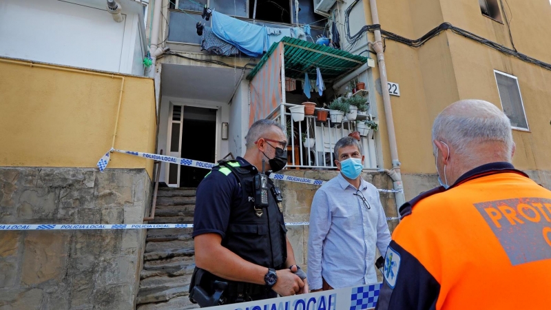 . En la imagen, el alcalde de Olesa, Miquel Riera (c), en el exterior del domicilio siniestrado en la calle Jaume Duran.