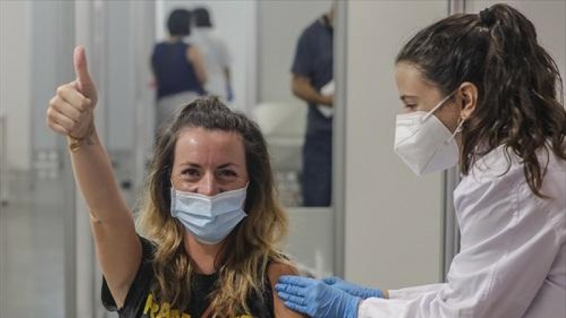 Una joven sonríe y saluda mientras recibe la vacuna contra el Covid-19 a una joven en el dispositivo puesto en marcha en la Ciutat de les Arts i les Ciències de Valencia, a 28 de julio de 2021, en Valencia, Comunidad Valenciana.
