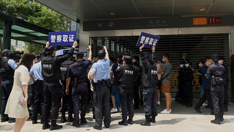 Agentes de la policía tratan de disolver la concentración de inversores y proveedores de la inmobiliaria China Evergrande, frente a su sede en la ciudad de Shenzhen, al sudeste del país, ante el temor de la que la empresa vaya a la quiebra y no les pague.