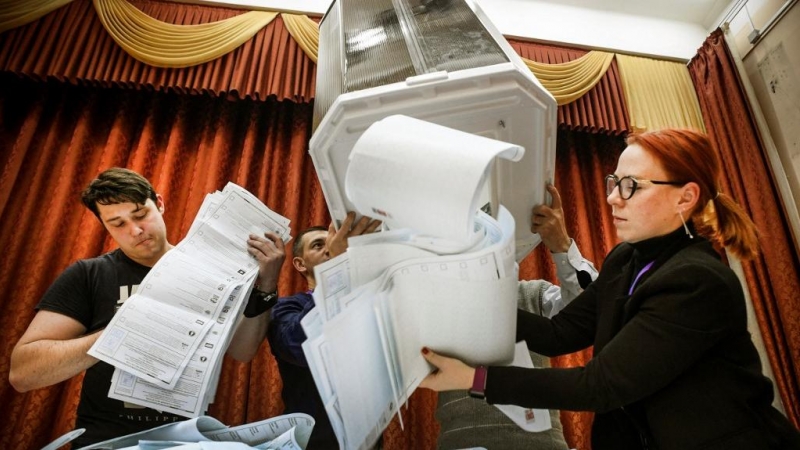 Los miembros de una comisión electoral local vacían una urna en un colegio electoral después del último día de las elecciones parlamentarias de tres días, en Moscú, el 19 de septiembre de 2021.