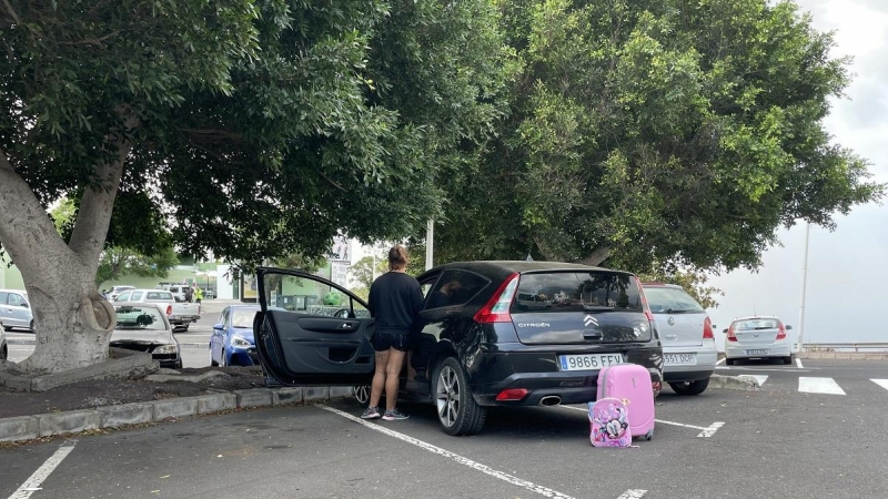 Sheyla de espaldas a la cámara y junto a su coche, en cuyo interior está su hija de cinco años.