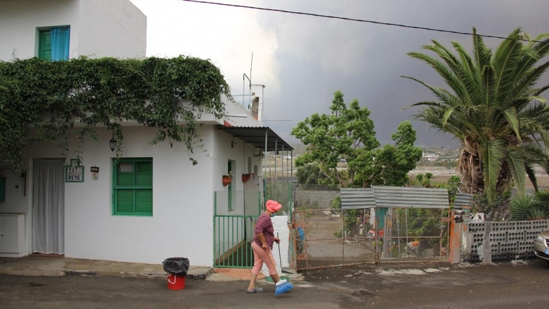Katia barre la puerta de su casa en La Aldea de La Laguna, cerca de Todoque, y amontona cenizas que no paran de caer del cielo.