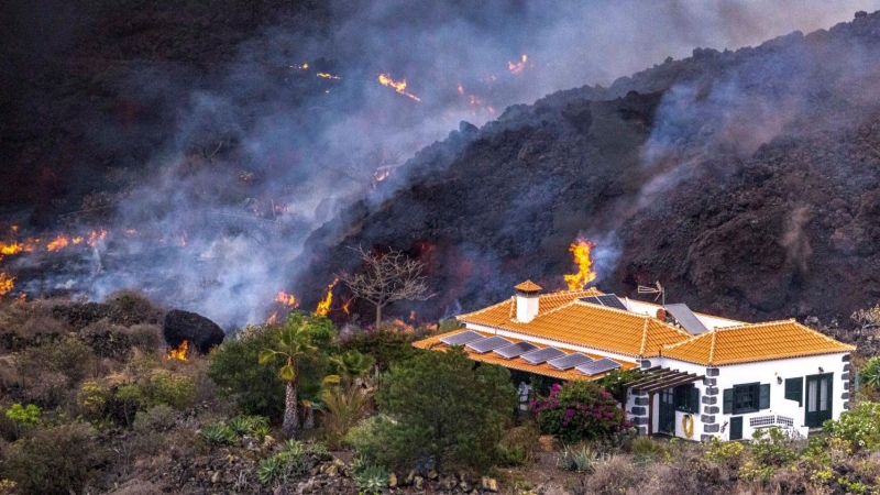 Una imagen tomada por un dron de la colada de lava del volcán de La Palma, a punto de arrasar con una casa, este 24 de septiembre de 2021.