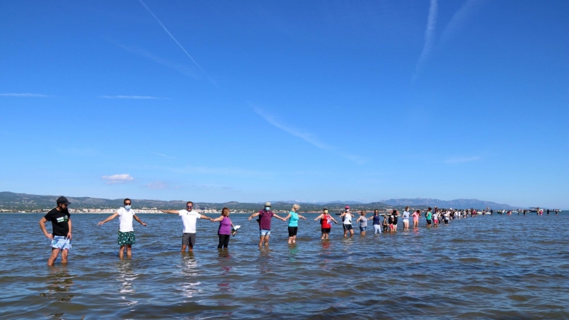 Pla general dels participants fent la cadena humana a la badia del Fangar, a l'Ampolla (Baix Ebre), per denunciar la regressió que pateix el delta de l'Ebre.