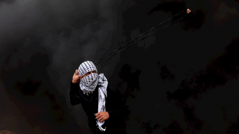 Un manifestante palestino lanza piedras con su honda a las autoridades israelíes durante una protesta contra los asentamientos israelíes en la aldea de Beita, cerca de Nablus, Palestina, este viernes
