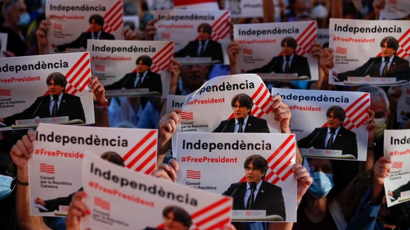 Manifestantes sosteniendo pancartas con la imagen de Carles Puigdemont, en una concentración en la Plaza de Sant Jaume en protesta por su detención en Cerdeña. REUTERS/Albert Gea