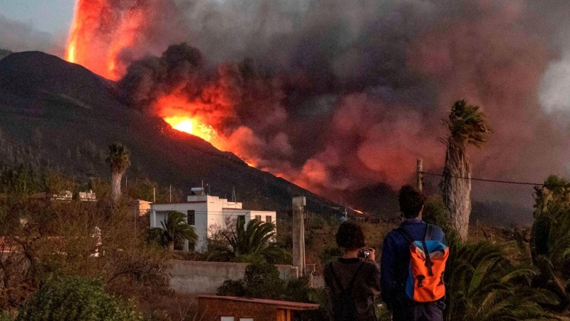 Dos personas observando la erupción del volcán en La Palma.