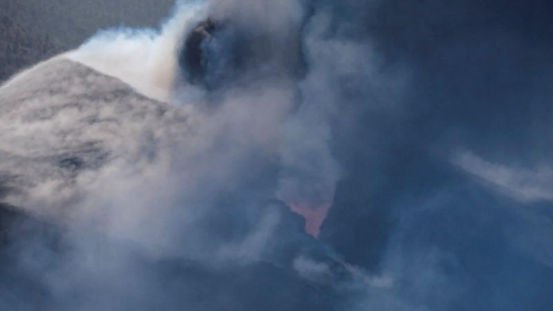 El volcán no cesa de expulsar lava rodeado de una potente columna de humo.