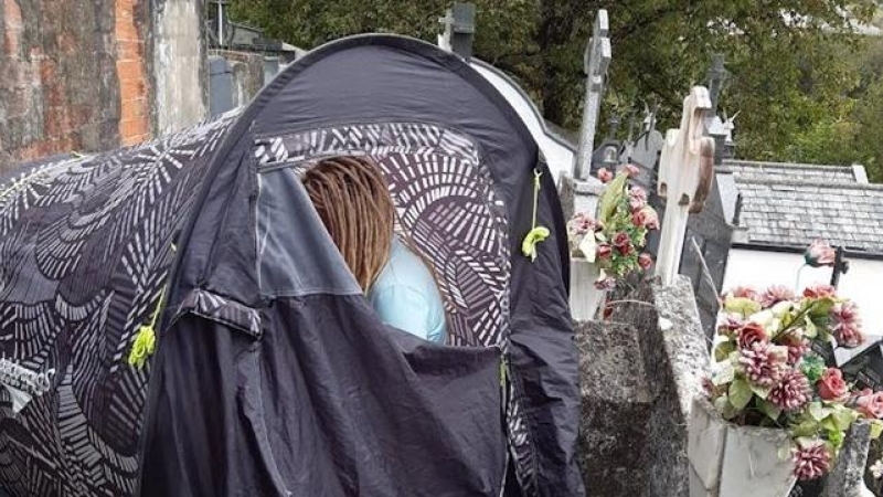 Mujer acampada sobre un nicho en el cementerio de San Lázaro en Lugo, Galicia, el pasado 2 de octubre.